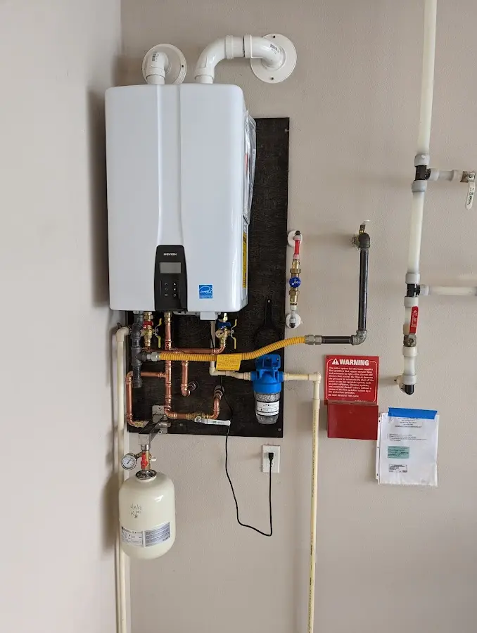 Professional plumber installing copper piping in a Burlington home